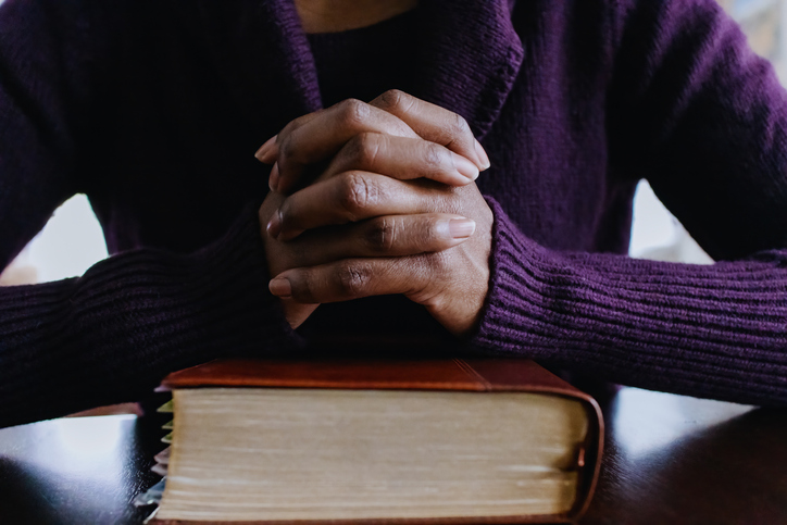 Woman Prays Before Reading Bible at Home