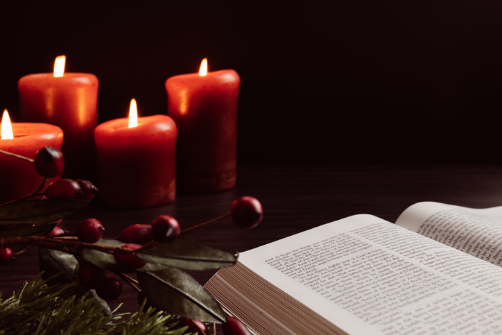 Open bible and lit red candles